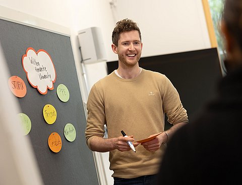 Ein Studierender im Bereich Management im Gesundheitswesen diskutiert im Seminar über ein Thema.