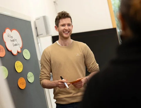 Ein Studierender im Bereich Management im Gesundheitswesen diskutiert im Seminar über ein Thema.