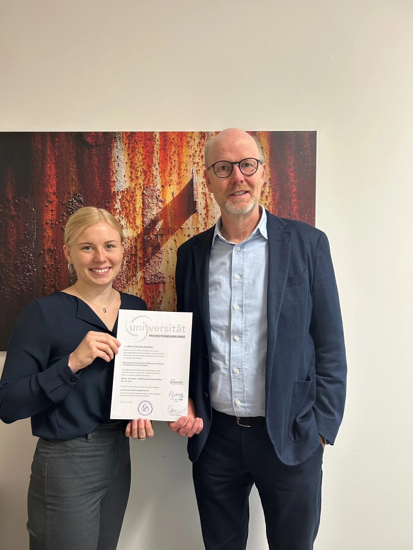 Dr. rer. pol.  Anne Kitschen mit Urkunde und Univ.-Prof. Dr.  Dirk Sauerland