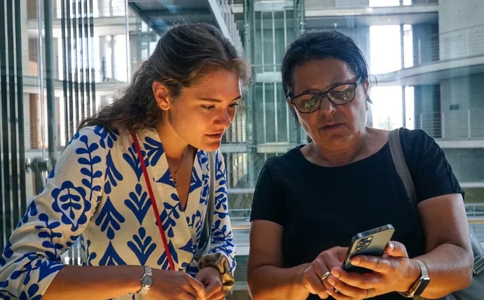 Frederike Westphalen und Gülistan Yüksel schauen zusammen auf ein Smartphone.