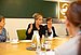 Mona Neubaur sits at the table and gestures with her hands as she speaks.