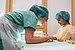 A student explains to a girl how her soft toy is about to be operated on.