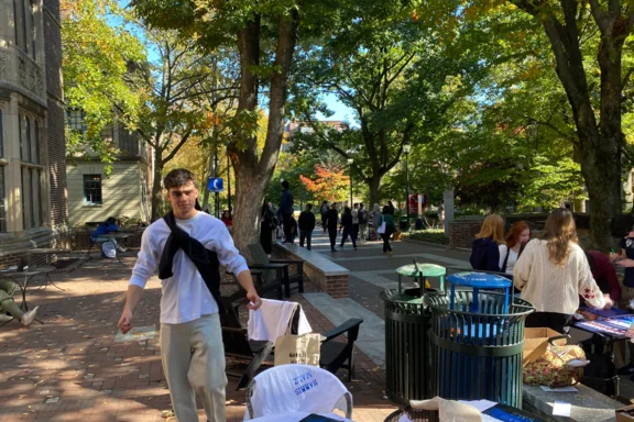 Eine Person inmitten eines Wahlkampf-Outdoor-Settings mit Stühlen und Plakaten.