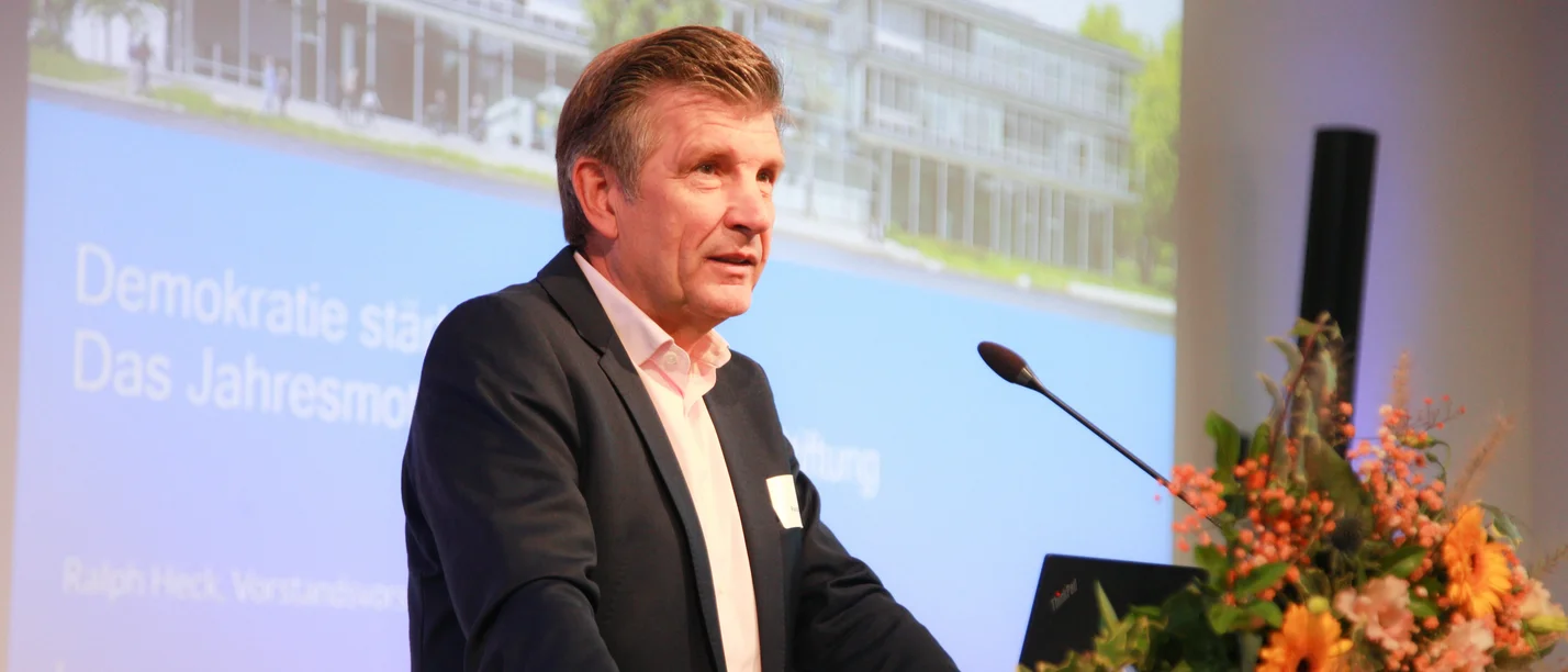 Portrait eines Mannes am Rednerpult.