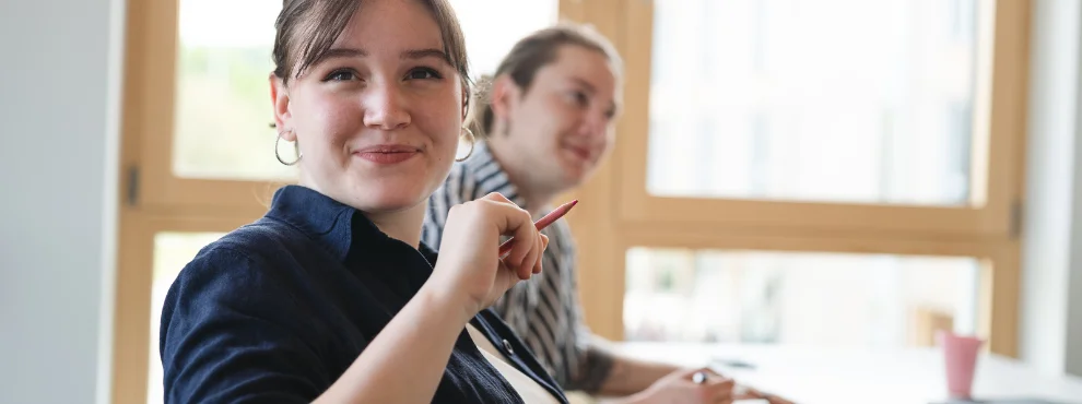 Eine Studentin lächelt in die Kamera.