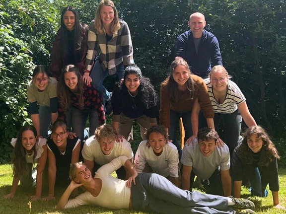 Gruppenbild der ersten LIC-Kohorte. Sie bauen eine Menschen-Pyramide auf dem Rasen.