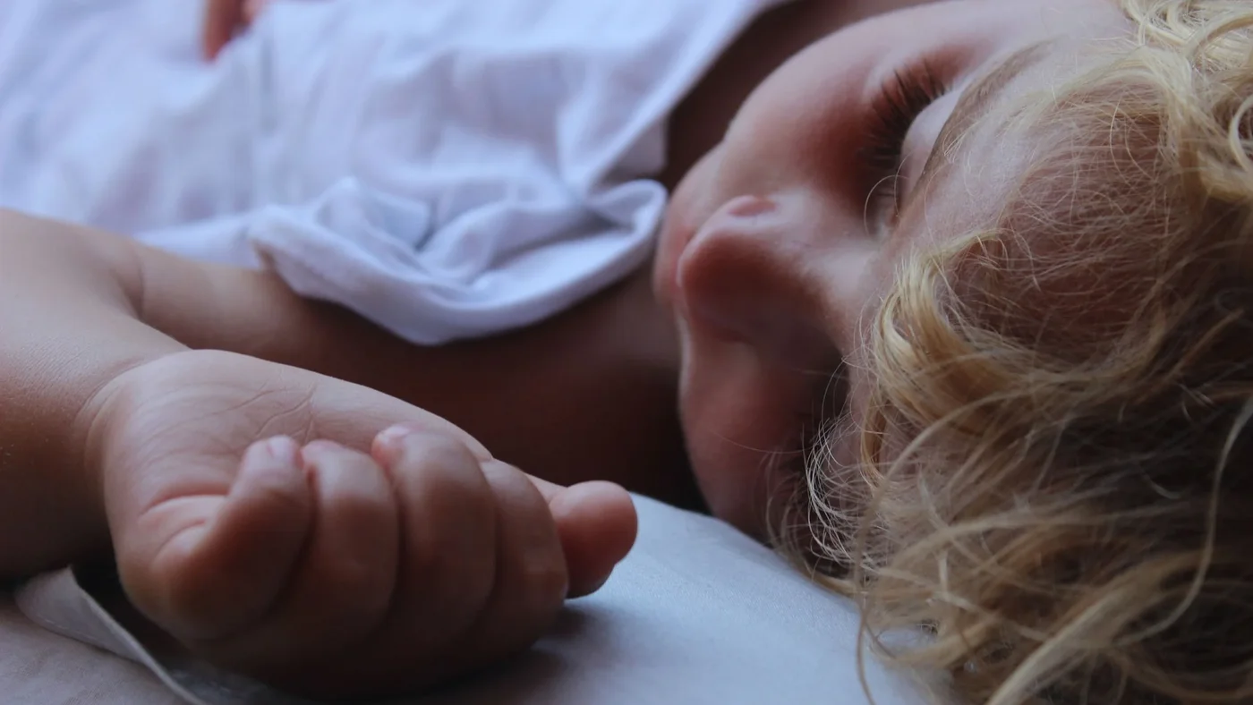 Nahaufname eines Kleinkinds, das auf dem Rücken liegt und schläft.