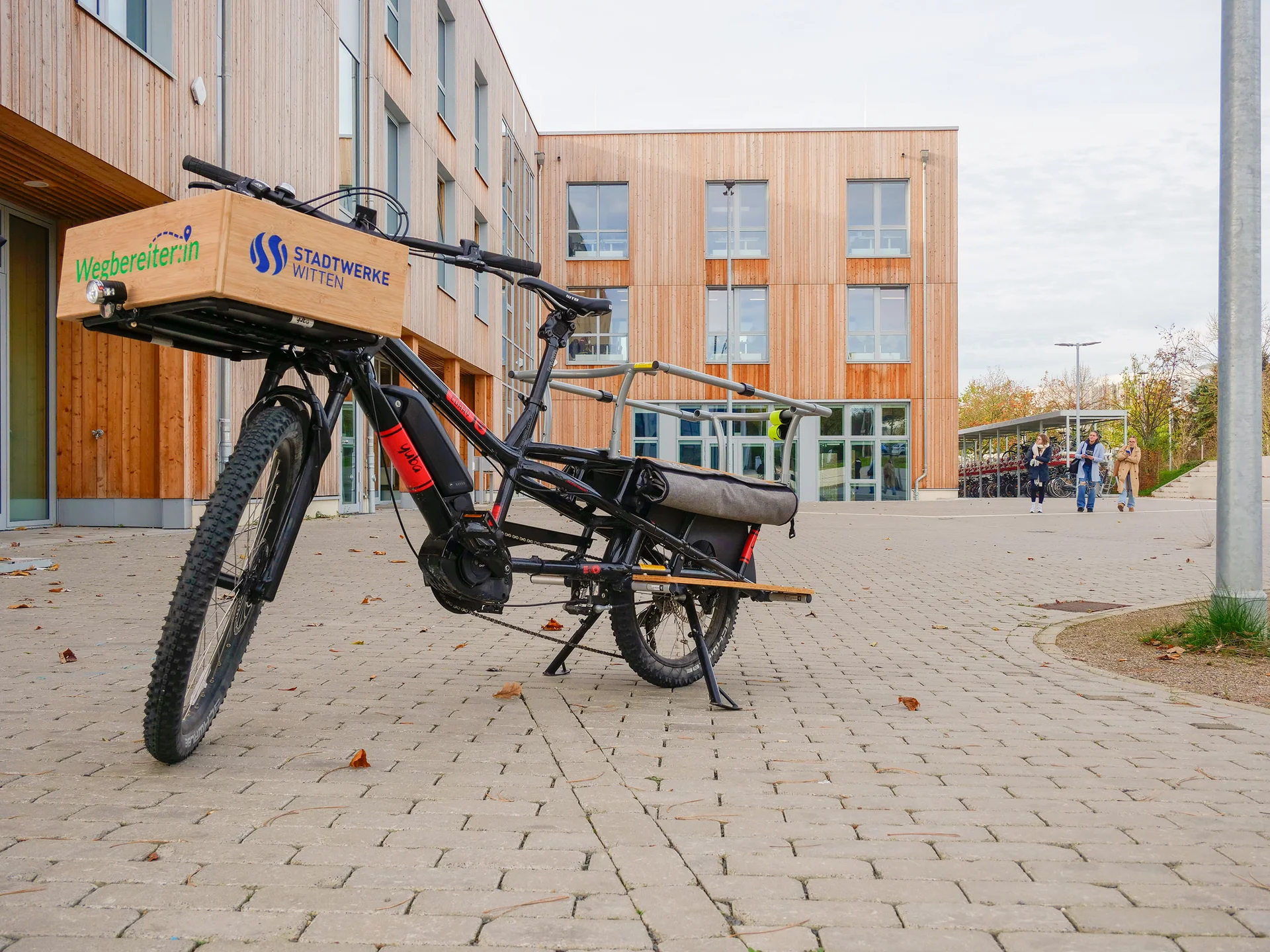 With initiatives such as its bike-sharing scheme for cargo bikes, UW/H is promoting sustainable mobility. (Photo: UW/H) A cargo bike takes centre stage in the photograph. The wooden façade of the university’s new building can be seen in the background.