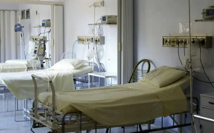 Drei leere Krankenhausbetten in einem Krankenzimmer.