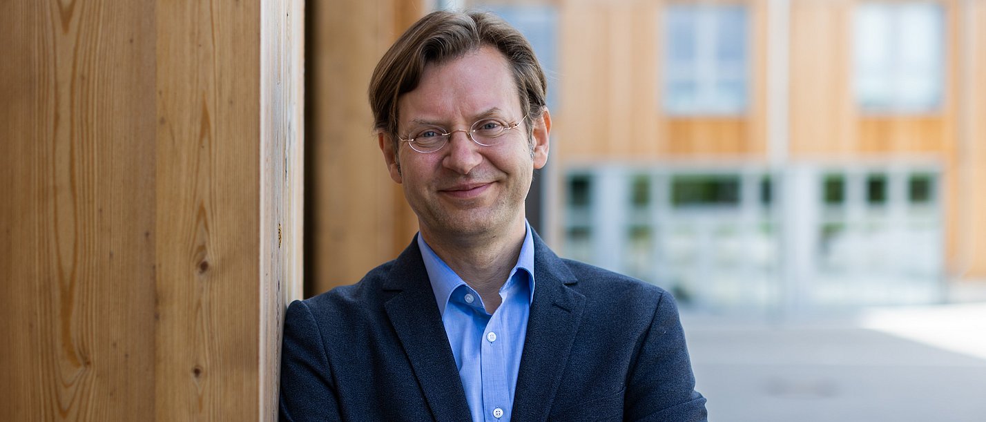 Portrait eines Mannes vor einer Holzwand 