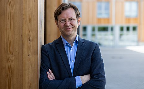 Portrait eines Mannes vor einer Holzwand 