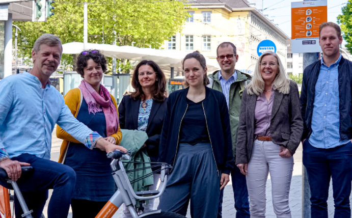 Eine Gruppe Menschen lächelt in die Kamera.