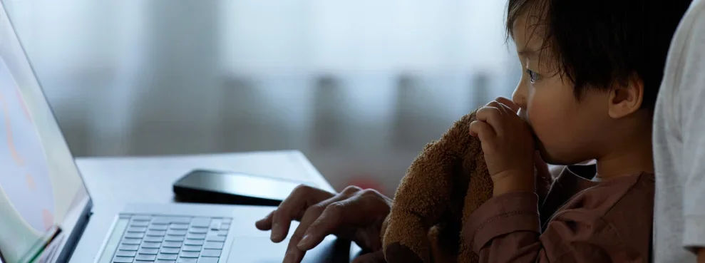 Ein Kind schaut auf einen Laptop.