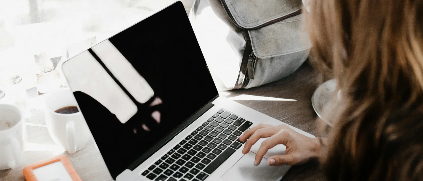 Das Kompaktprogramm Unternehmenspraxis für NextGens gibt die Antworten, die angehende Unternehmer:innen, ihre Partner:innen und Young Professionals in Familienunternehmen suchen. (Foto: pexels | Andrew Neel) Blick über die Schulter einer Frau, die an einem Laptop sitzt.