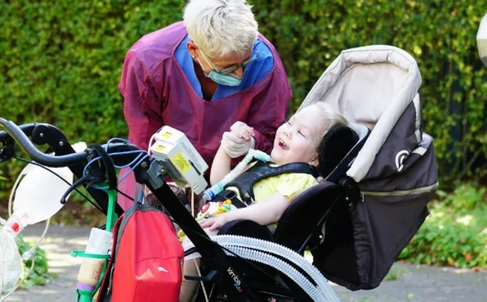 Frau mit einem Kind, das eine komplex-chronische neurologische Erkrankung hat