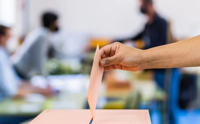 Sachsen-Anhalt vor der Wahl: Entscheidend ist nicht, wer gewinnt (Foto: Canva) Eine Hand wirft einen Wahlumschalg in die Urne.