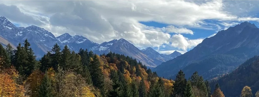 Berglandschaft mit Bäumen und Wolken