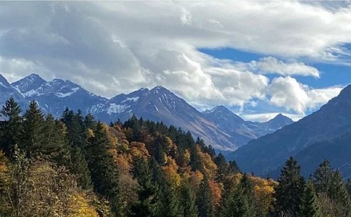 Mountain landscape with trees and clouds