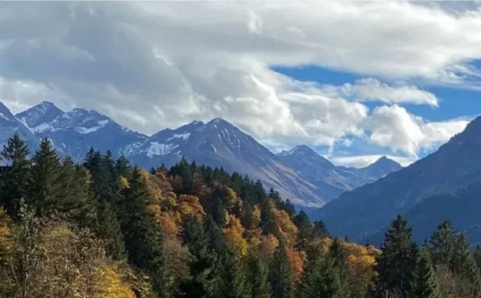 Berglandschaft mit Bäumen und Wolken