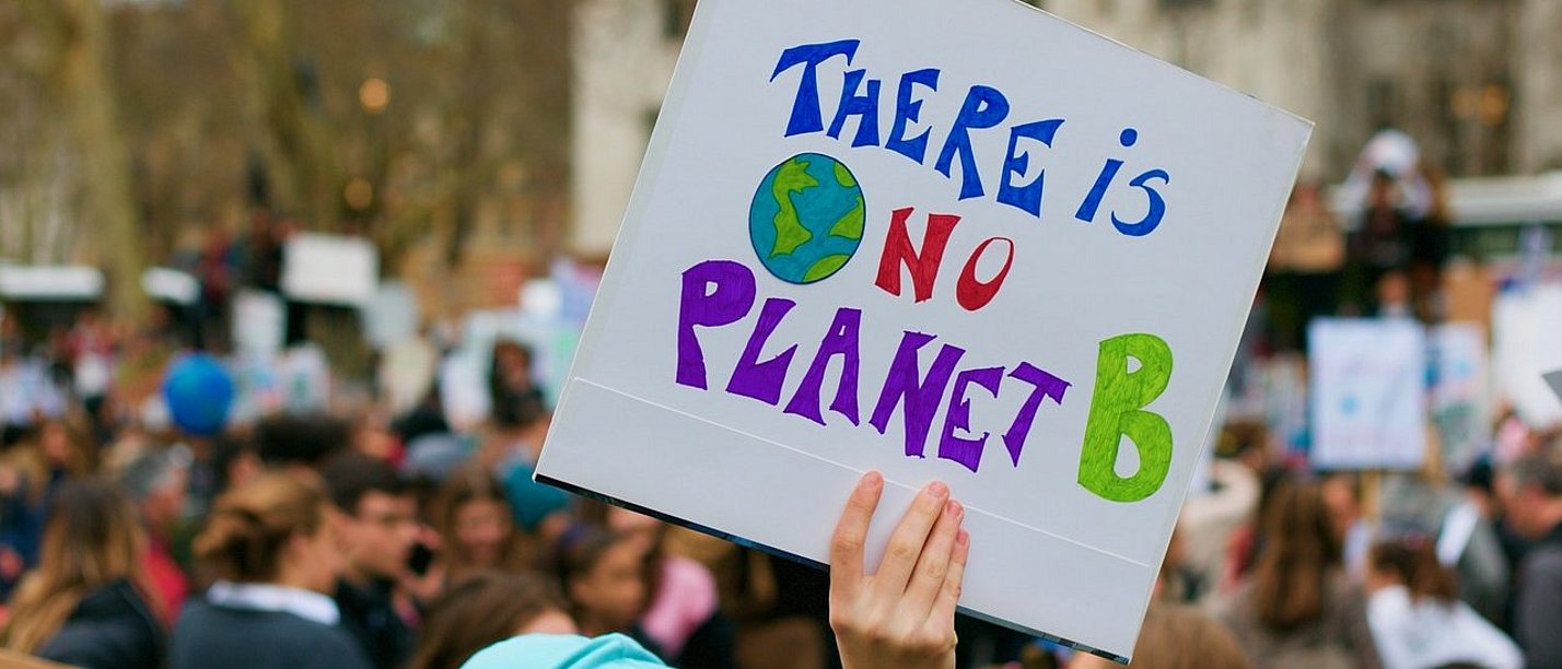Wittener Klimadialog zum Thema „Gesundheitsschutz braucht Klimaschutz“ (Foto: pixabay | Kevin Snyman) Eine Hand hält ein Plakat mit der Aufschrift "There is no planet B" hoch.