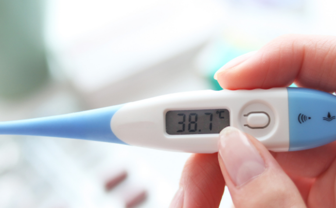 One hand holds a clinical thermometer.