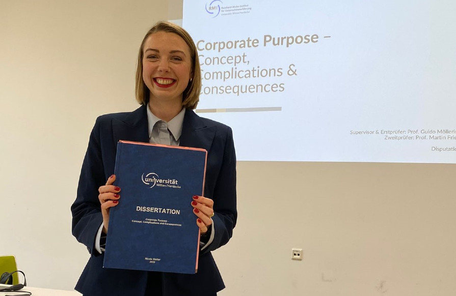 Das RMI Team gratuliert Nicole Steller zu Ihrer erfolgreichen Dispuation (©RMI) Nicole Steller hält ihre Dissertation in der Hand, die sie gerade erfolgreich verteidigt hat (Foto vom RMI)