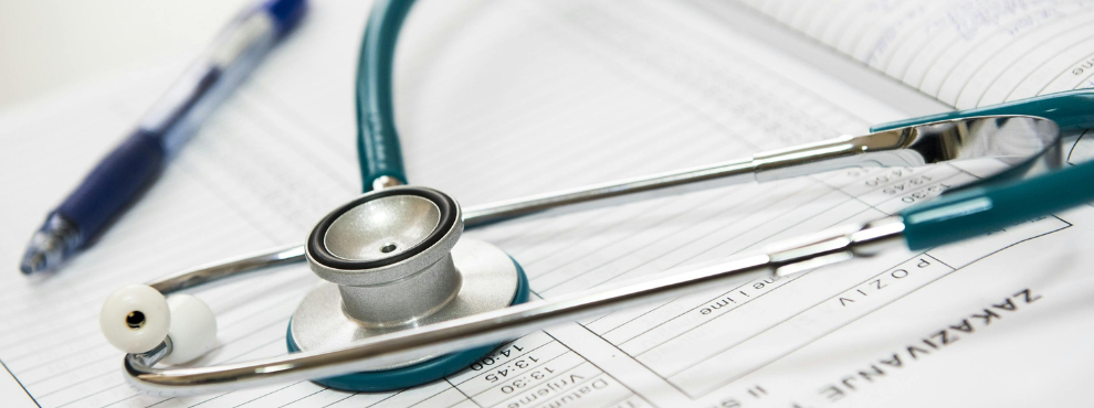 Stetoscope and ballpoint pen lie on a sheet of paper.