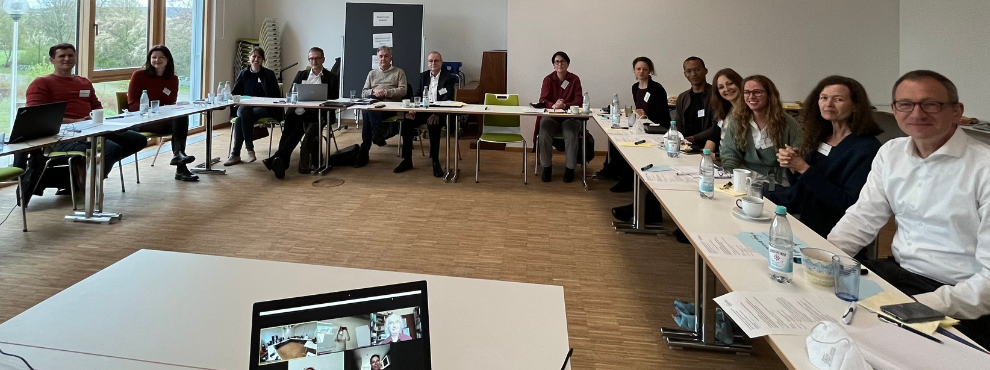 The GESCO research project aims to develop new care concepts in which gender-, culture- and role-related factors are given greater consideration than before. (Photo: UW/H) A group of people sit at tables arranged in a U-shape and look into the camera.