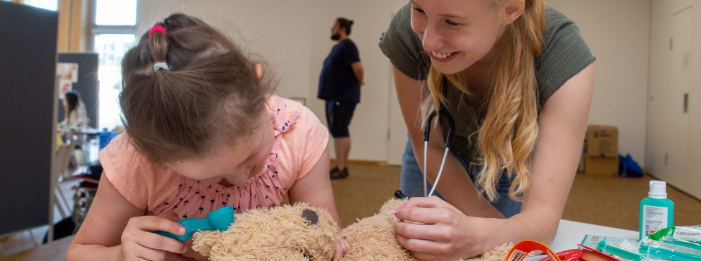 The teddy bear is thoroughly examined. (Photo: UW/H) A girl examines a teddy bear together with a student.