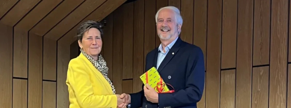 Silbernes Ehrenzeichen an Prof. Dr. Andreas Schulte verliehen (Foto: Bundesverbandes der Zahnärztinnen und Zahnärzte des Öffentlichen Gesundheitsdienstes) Eine Frau und ein Mann schütteln sich die Hand und schauen in die Kamera.