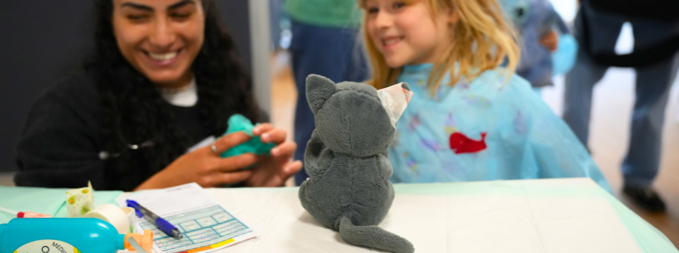 Die Teddyklinik an der UW/H findet bereits zum siebten Mal statt. (Foto: UW/H | Kristina Eichhorn) Eine Studentin und ein Mädchen bereiten eine Plüschkatze für den OP vor.