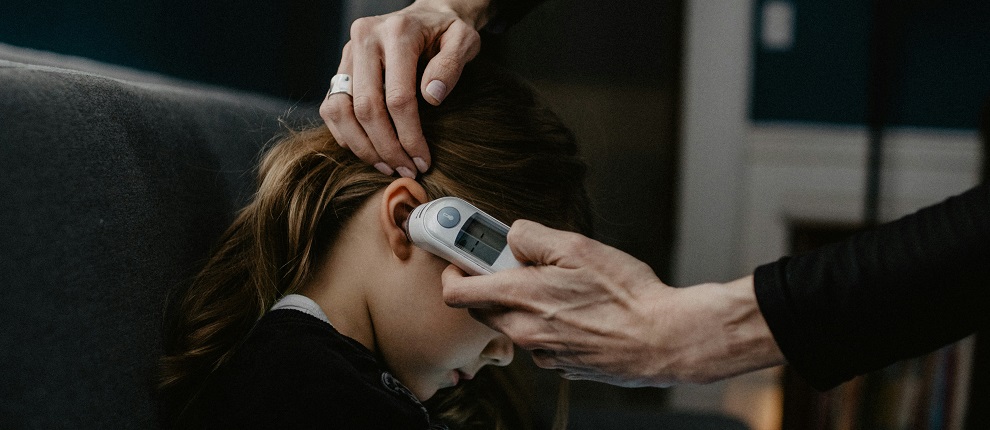 Taking a child's temperature correctly Child with clinical thermometer in ear